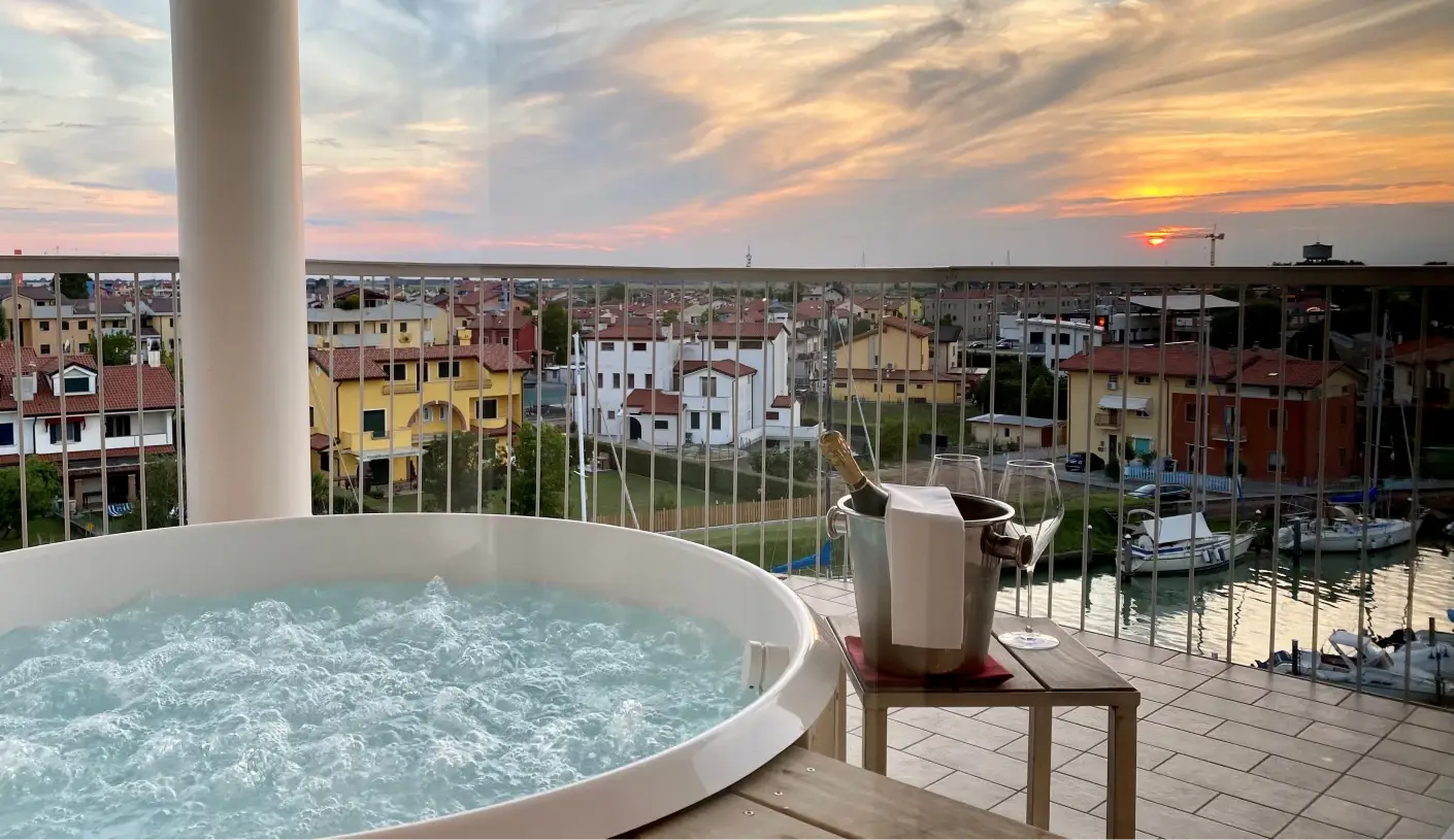 DELUXE VISTA     Junior Suite mit einem geräumigen Balkon, wo ein Whirlpool liegt: genießen Sie einen romantischen Blick auf Caorle.